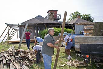 Volunteers clean debris from porch project